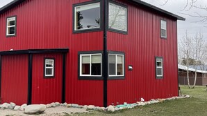Un bâtiment rouge à deux étages, doté de nombreuses fenêtres et d’une cheminée bien visible.