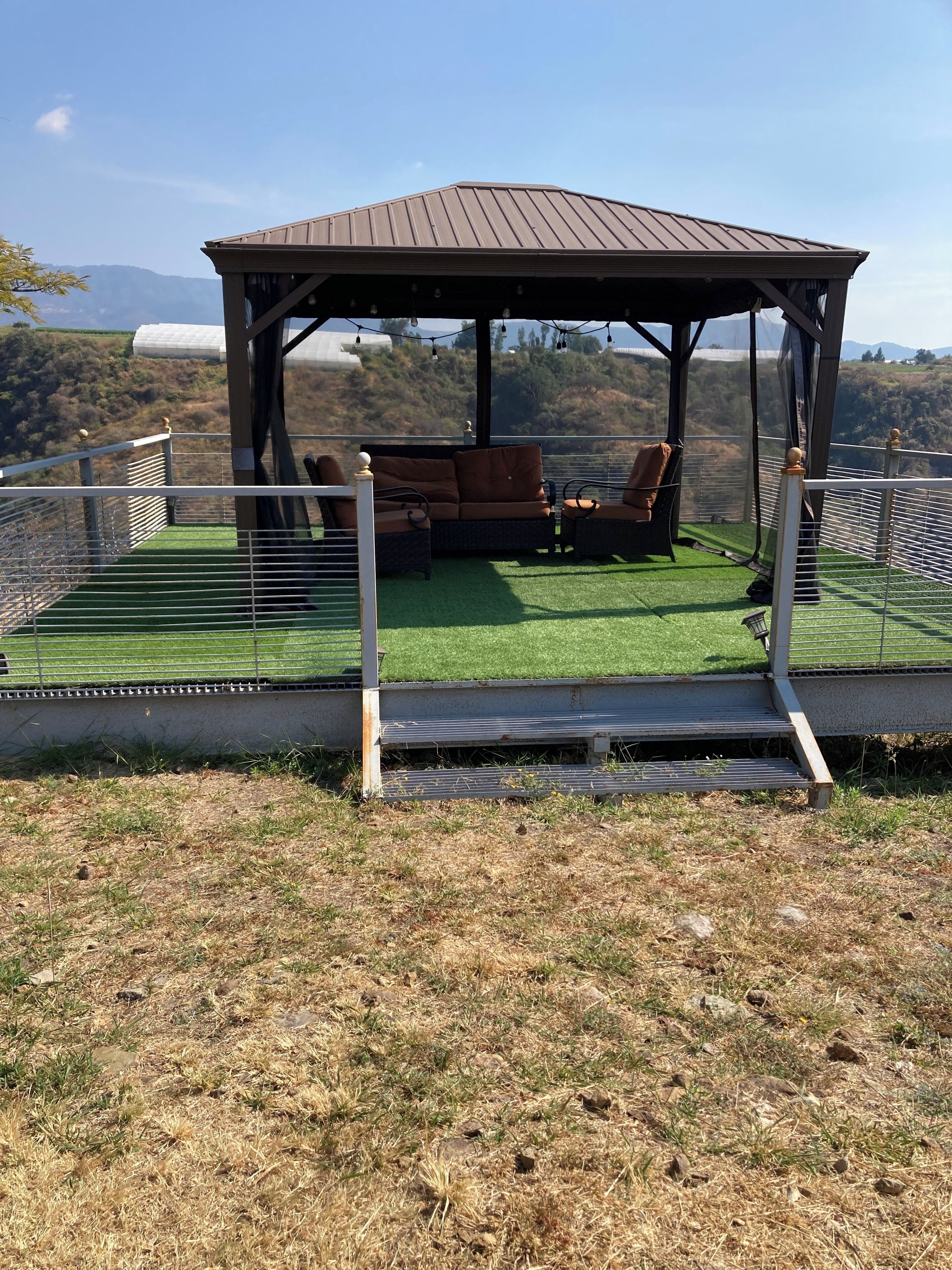 Un espacio de estar al aire libre cubierto con vistas del paisaje circundante.