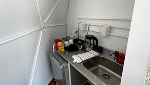 A compact kitchenette with a sink, a coffee maker, and a small trash bin. - ixkapada glamping  (Ixtapan de la Sal)