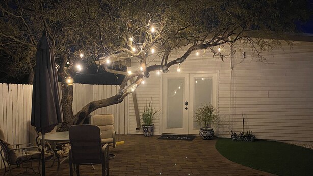 A backyard patio with a brick floor, a white fence, a door, and outdoor furniture. - Feel like in home in this beautiful guest casita with mountains views. (Tucson)