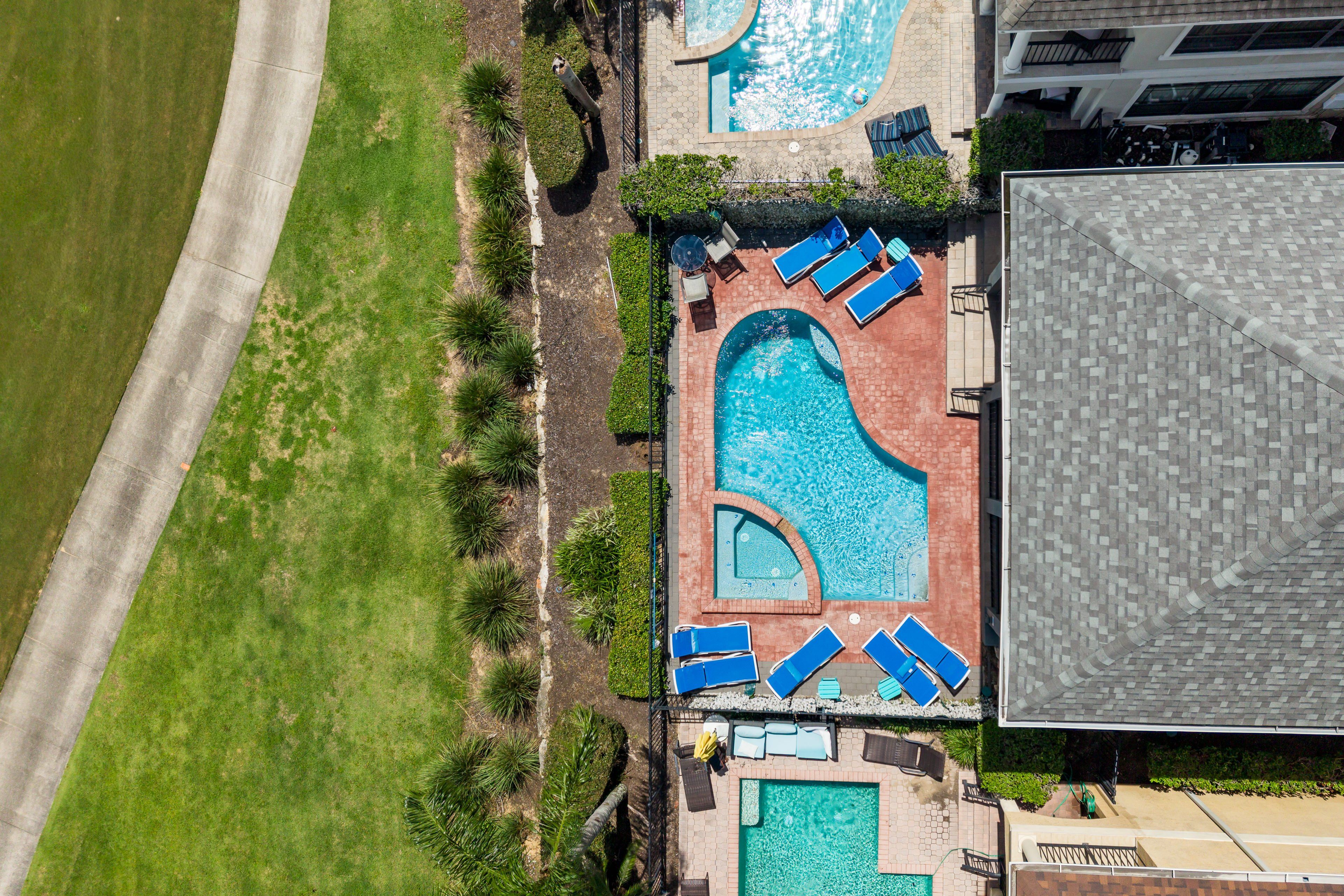 A rooftop swimming pool with multiple lounge chairs and a separate smaller pool area.