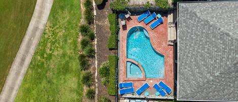 A rooftop swimming pool with multiple lounge chairs and a separate smaller pool area.