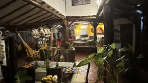 Ein rustikales Interieur mit Essbereich, Holzbalken und einer Hängematte.