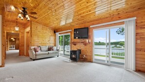 Een houten interieur met een bank, televisie en een open haard.