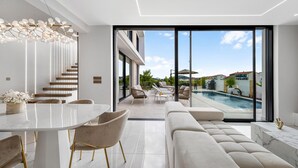 A modern interior with a dining area, sofa, and a view of a swimming pool. - Lovely home in Tribunj with private swimming pool, can be inside or outside (Tribunj)