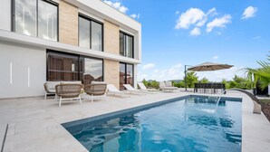 A modern outdoor pool area with lounge chairs, a table, and an umbrella. - Lovely home in Tribunj with private swimming pool, can be inside or outside (Tribunj)