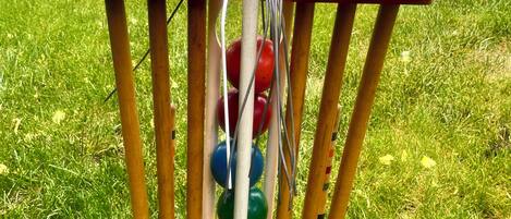 Un soporte de madera para bates de cricket con varios bates y pelotas.