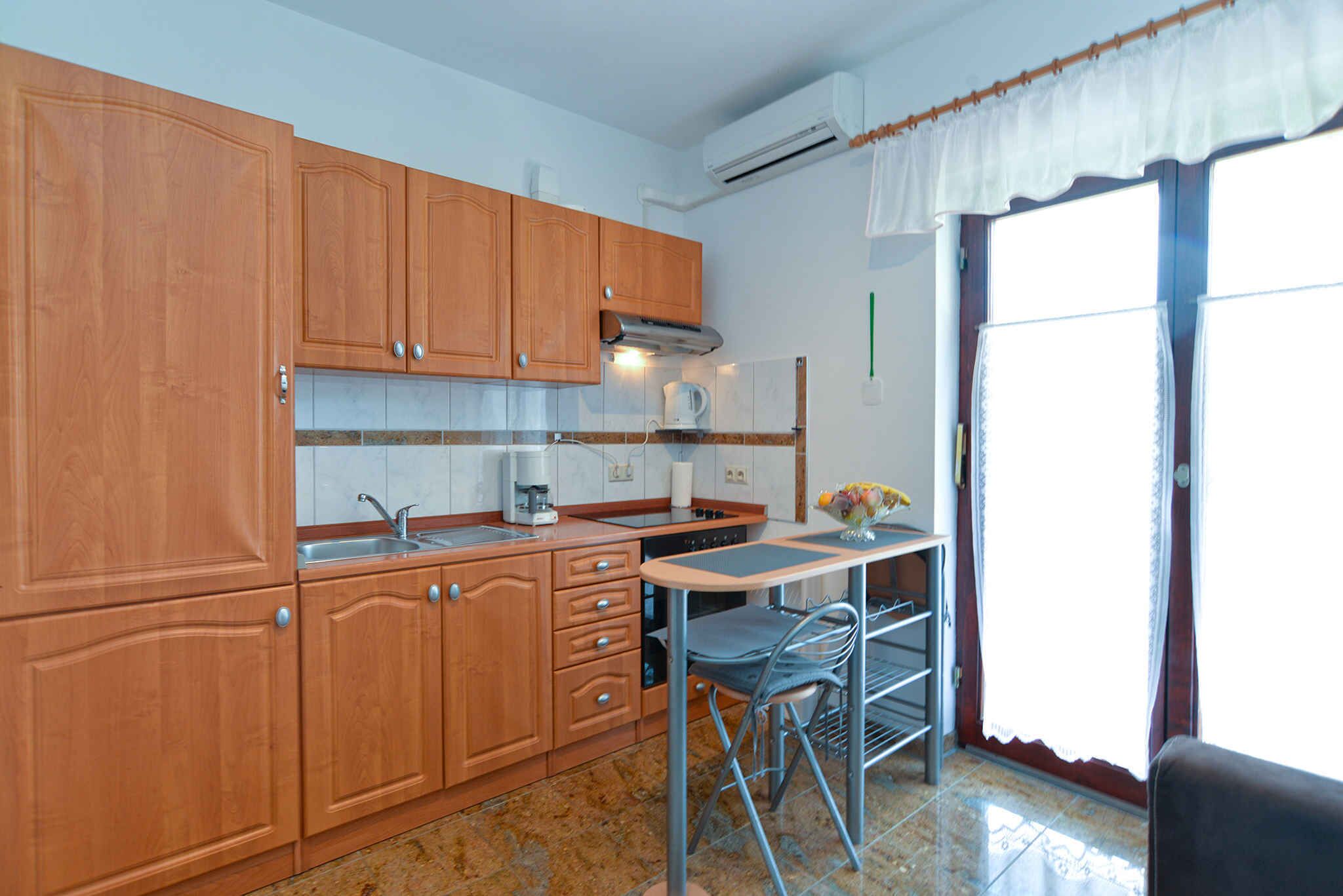 A kitchen with wooden cabinets, a coffee maker, and a dining area with a table and chairs.