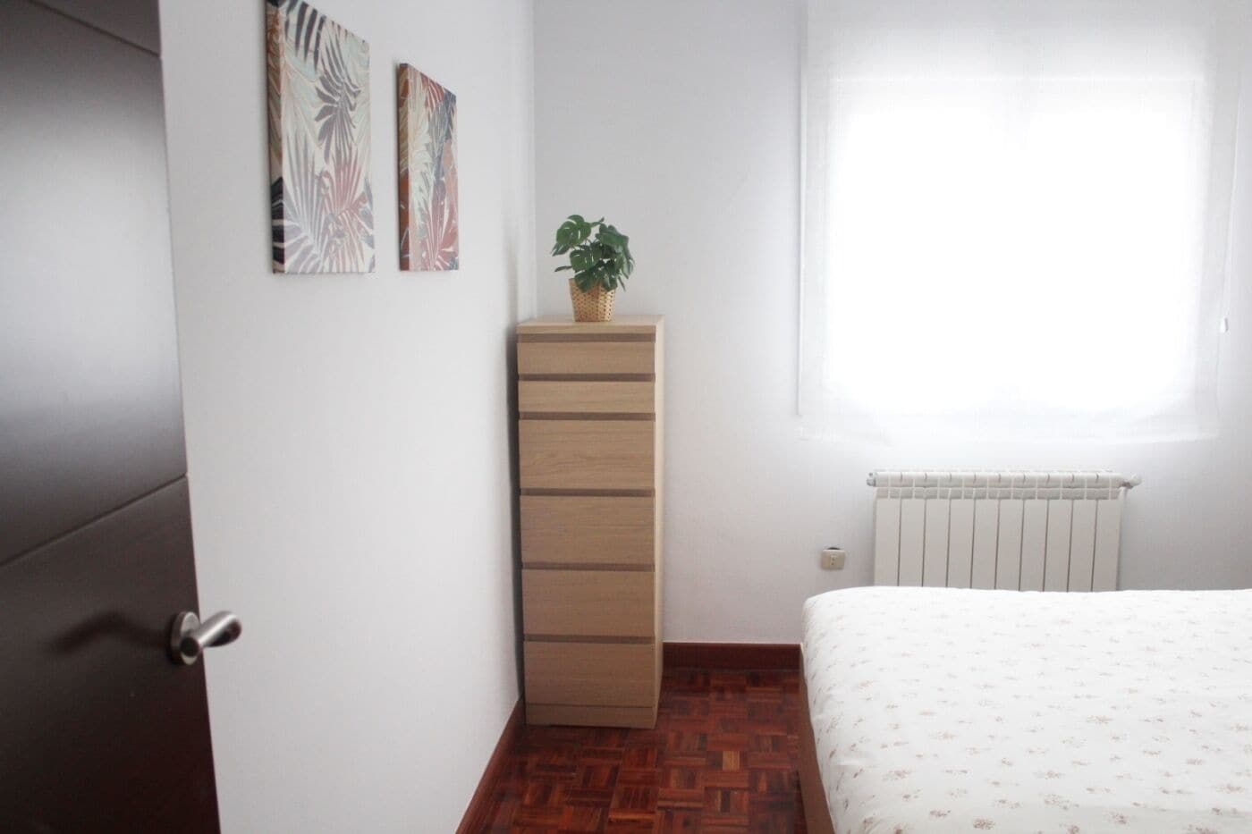 3 dormitorios y tabla de planchar con plancha