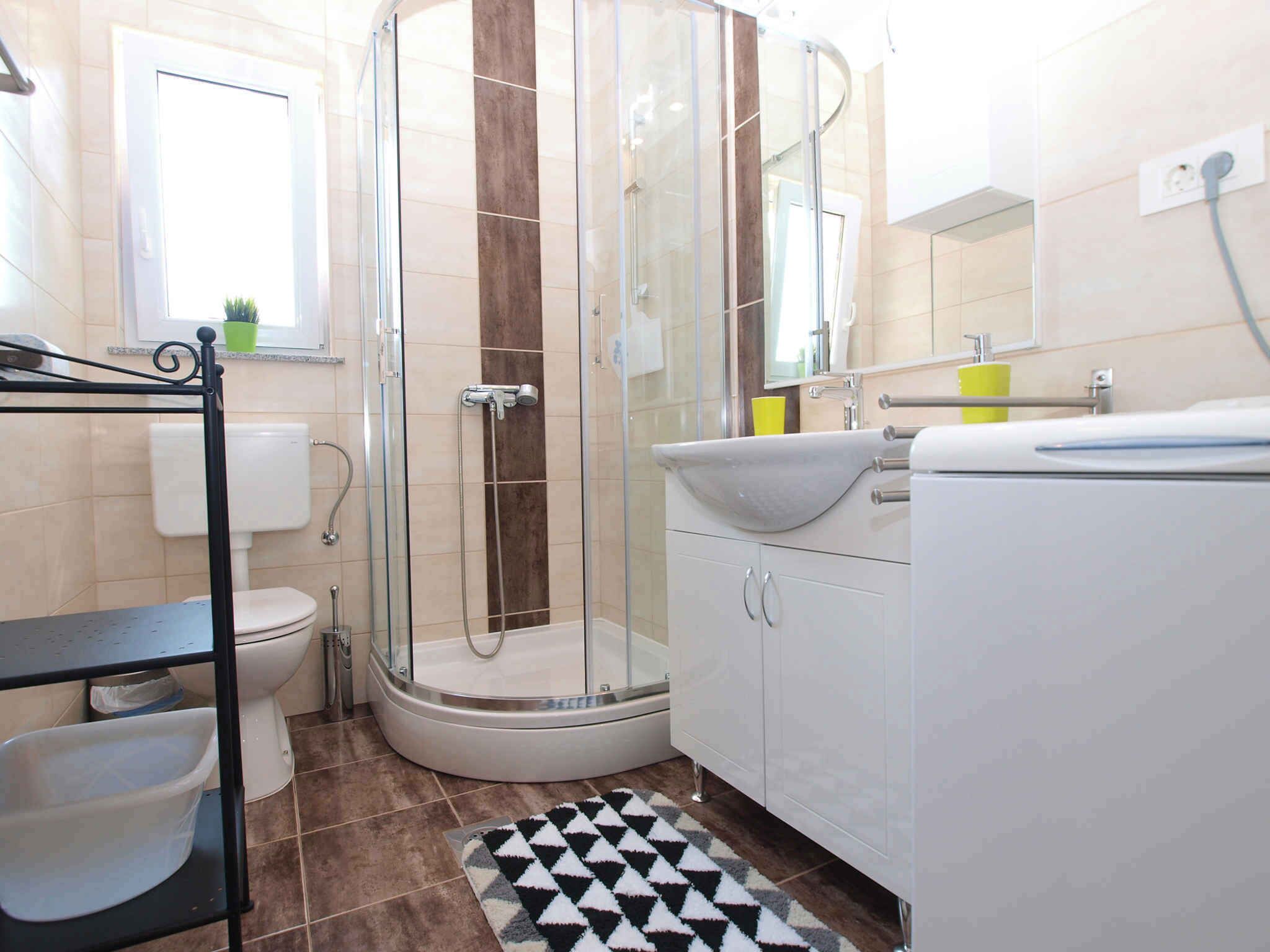 A modern bathroom with a glass-enclosed shower, a toilet, a sink, and a vanity.