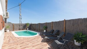 A rooftop pool area with a wooden deck, lounge chairs, and potted plants. - CASA ROJA - Lovely villa with private pool (Vejer de la Frontera)