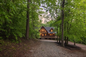 Eine Hütte mit Veranda, umgeben von Bäumen.