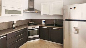 A modern kitchen with a stainless steel refrigerator, oven, and stove.