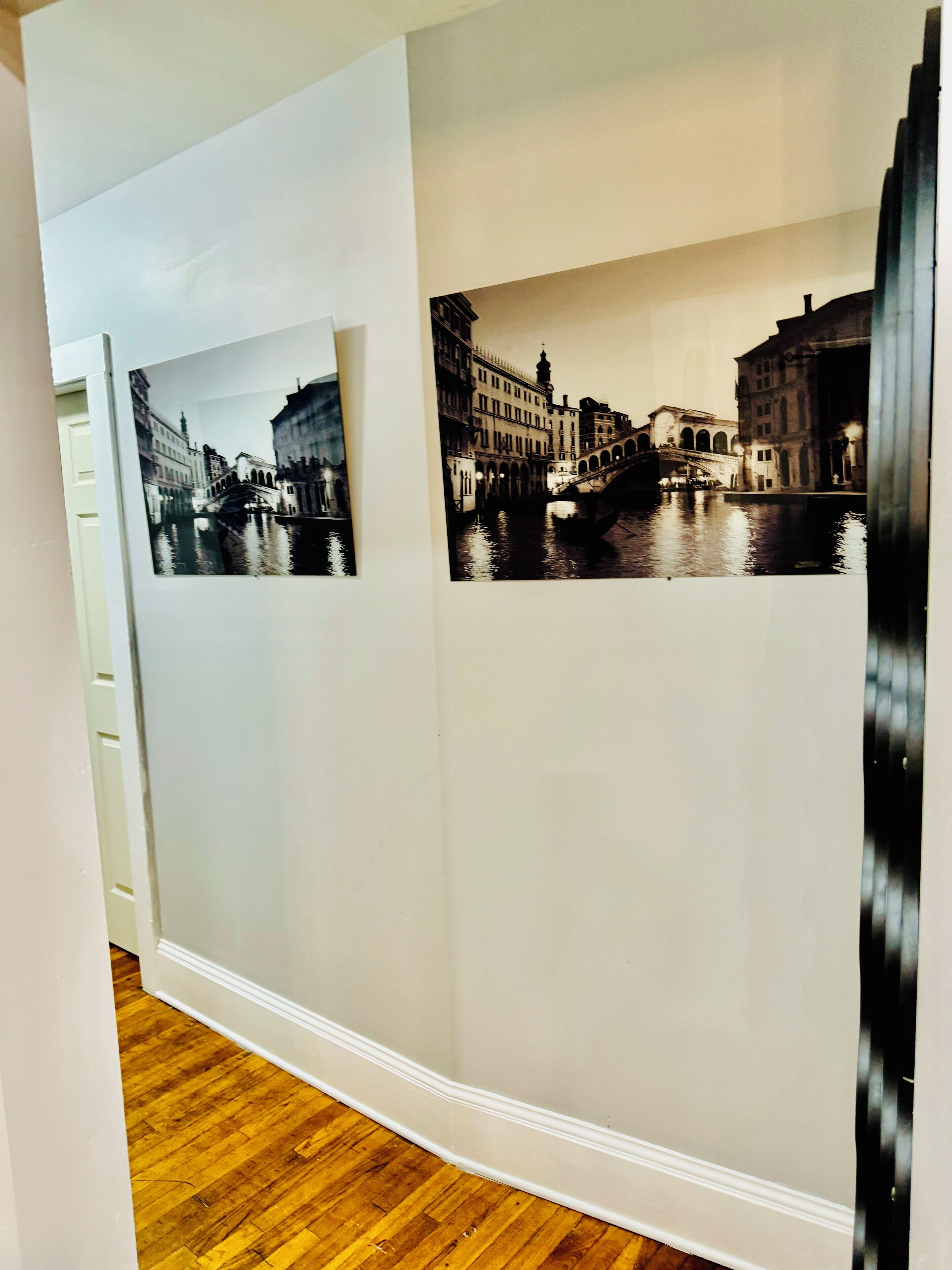Corredor com duas fotografias a preto e branco de um canal e edifícios.