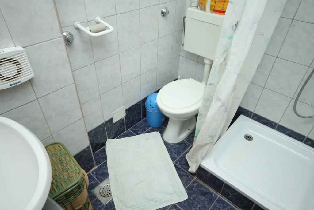 A small bathroom with a toilet, a sink, a bathtub, and a shower curtain.