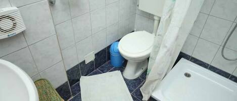 A small bathroom with a toilet, a sink, a bathtub, and a shower curtain.