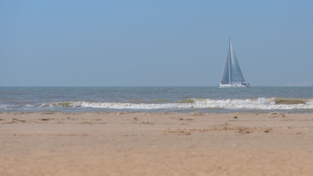 Un veler sobre un mar tranquil amb un cel serè.