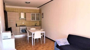 Un espace de vie compact comprenant une kitchenette, un coin repas et un canapé.