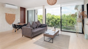 A modern living room with a sofa, coffee table, and dining area.