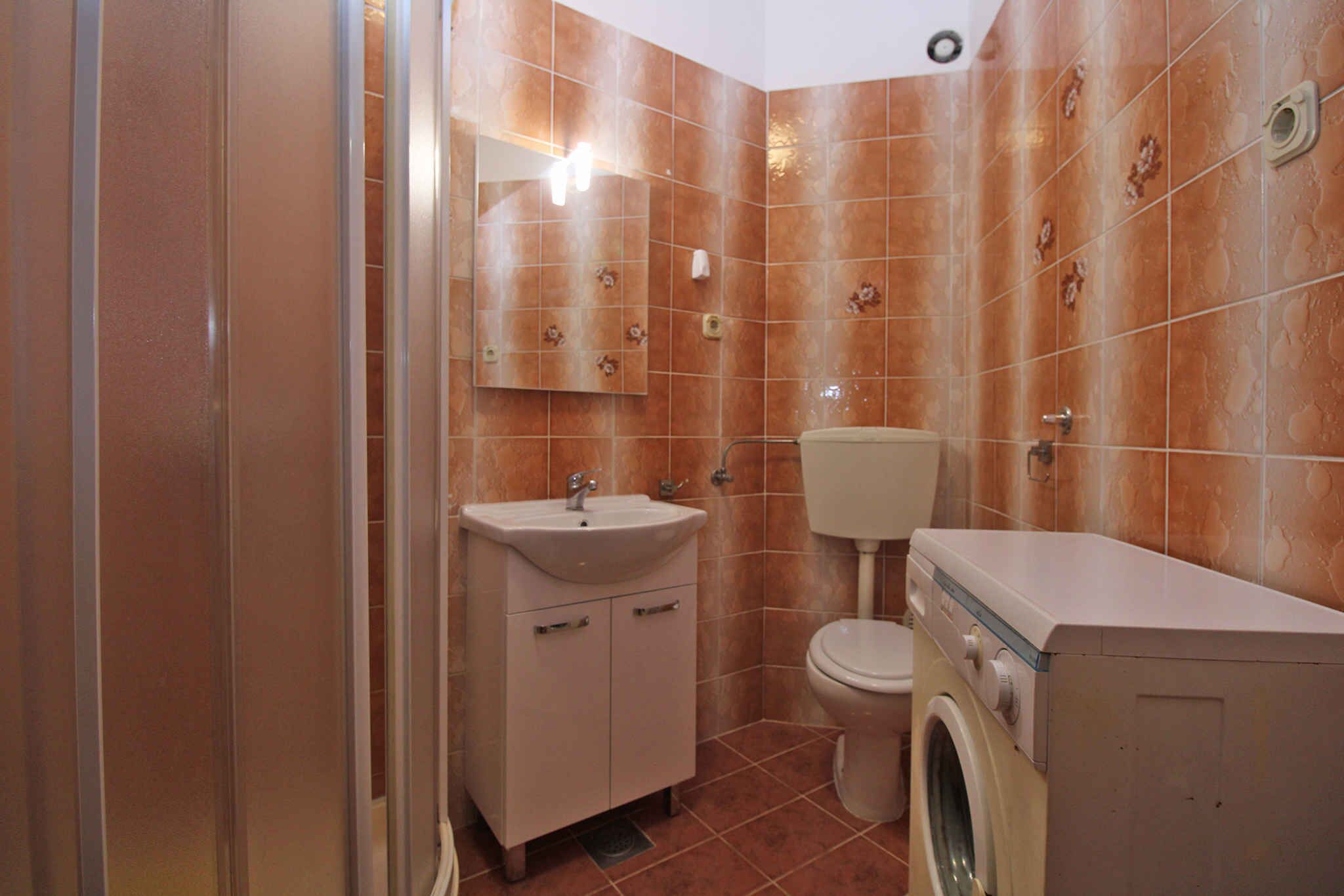 A compact bathroom with a sink, toilet, and washing machine.