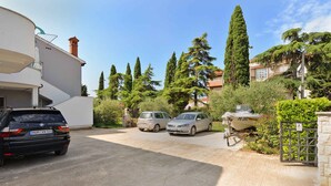 A residential area with parked cars, a boat, and a gate.