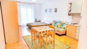 A compact living space with a bed, sofa, dining table, and kitchenette. - Holiday apartment with air conditioning (Fažana)