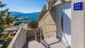 Un immeuble avec une enseigne indiquant « STUDIO APARTMAN » et offrant une vue sur la mer.