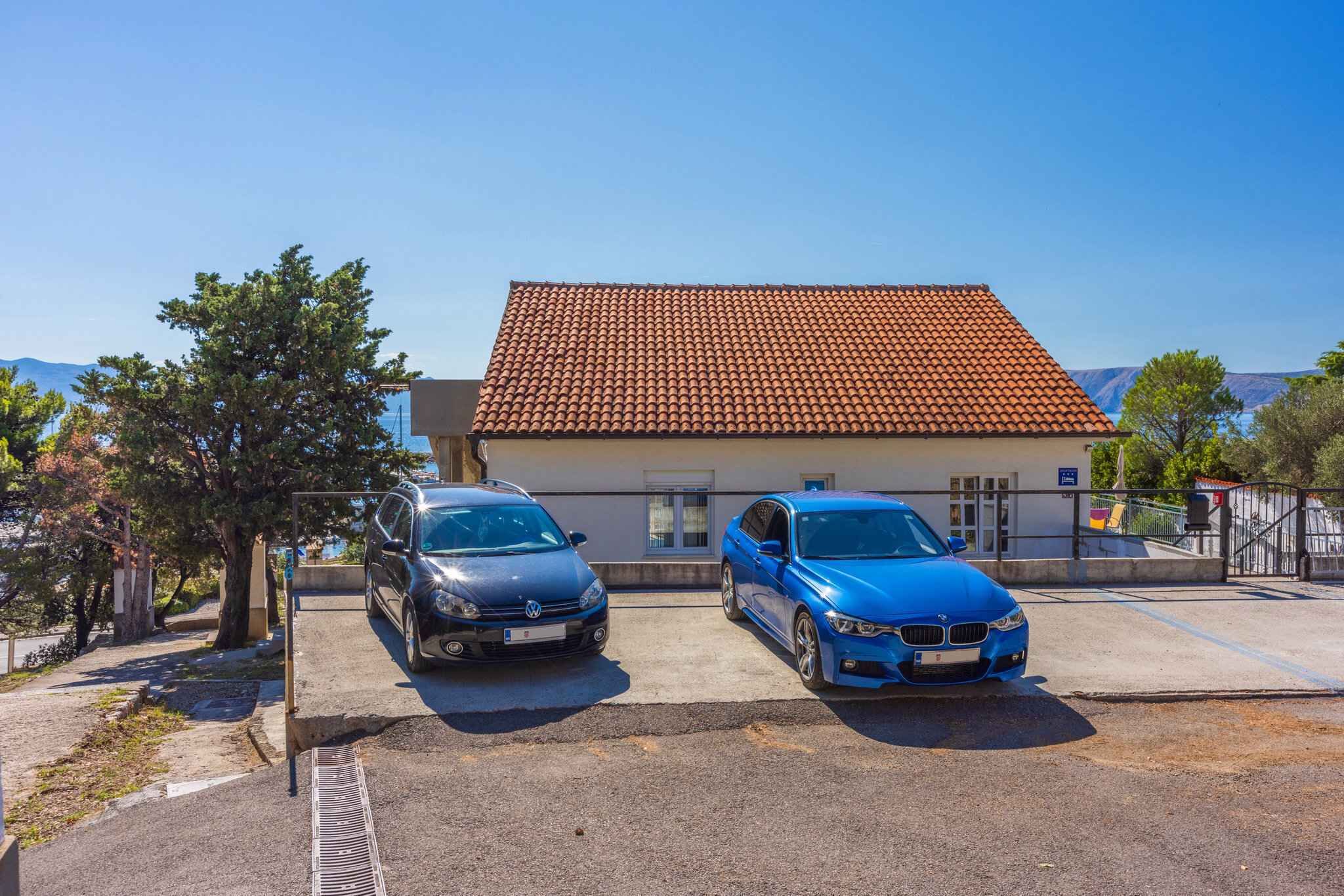 Dos coches aparcados frente a un edificio con techo de tejas.