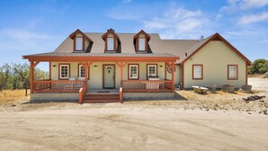 A two-story house with a porch, a front door, and a garage.