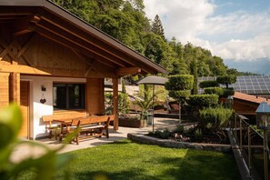 A wooden cabin with a patio, solar panels, and a garden. - Chalet Jasmin – Spacious Chalet with Garden and Olive Tree, Ideal for Relaxing Getaways (Rifiano)