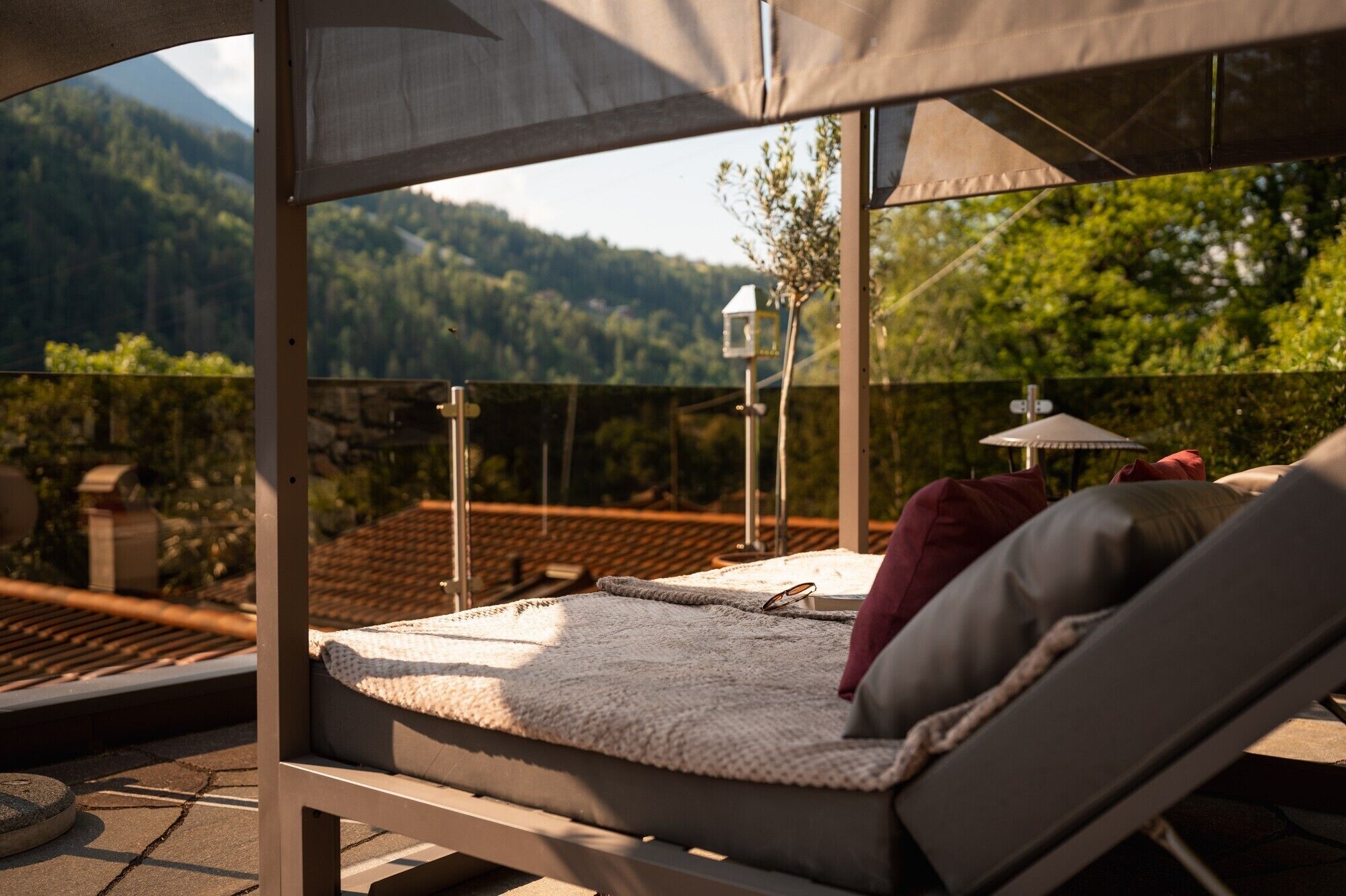 A sunlit outdoor seating area with a view of a mountain landscape.