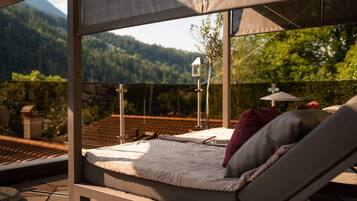 A sunlit outdoor seating area with a view of a mountain landscape.