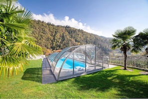 Una piscina cubierta con paredes de vidrio que ofrece vistas despejadas de un paisaje montañoso.