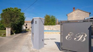 A residential property with a stone house, a swimming pool, and a gated entrance. - Villa with terrace for 2 people (Orbanići)