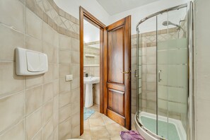 A bathroom with a shower, a sink, and a toilet. - Villa la Perla e le Conchiglie Tanca Piras (NEBIDA)
