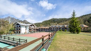 Un hôtel composé de plusieurs bâtiments, doté d’un court de tennis et situé dans un cadre montagneux.