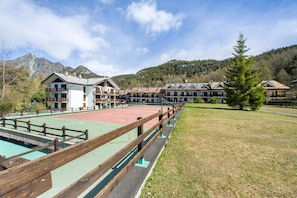 A hotel with multiple buildings, a tennis court, and a mountainous backdrop. - Holiday Home 'Gioiello Col De Joux' with Mountain View, Private Garden and Wi-Fi (saint vincent)