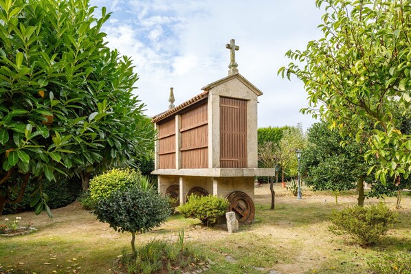 A small building with a cross on top, surrounded by greenery.