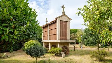 Un pequeño edificio con una cruz en la parte superior, rodeado de vegetación.