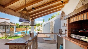 An outdoor patio with a stone bar, hanging lights, a brick oven, and a pool area. - Holiday Home 'Vila River Sublime' with Private Pool, Wi-Fi and Air Conditioning (Valada)