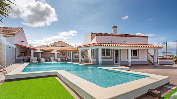 A swimming pool with a surrounding deck, a covered outdoor seating area, and a building with a tiled roof. - Holiday Home 'Vila River Sublime' with Private Pool, Wi-Fi and Air Conditioning (Valada)