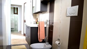 A modern bathroom with a toilet, bidet, and sink, a towel rack, and a visible toilet paper holder. - Villa 'Ll04 Hikari with Outdoor Spaces', Private Garden, Wi-Fi & Air Conditioning (San foca)