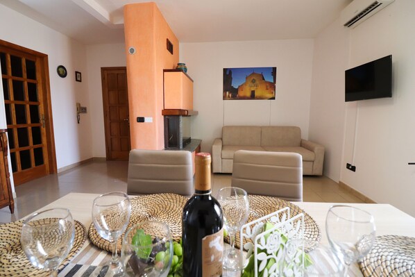 Un salon avec une table mise pour le repas, un canapé, un téléviseur et une porte.