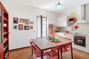 Une cuisine équipée d’une table à manger, de chaises et de divers appareils de cuisine.