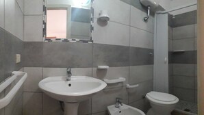Kylpyhuone, jossa on jalkapallipylväsallas, wc, bidee ja suihku.