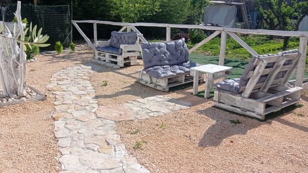 A garden patio with stone pathways, wooden furniture, and a rustic fence. - Apartment 'Deluxe Room' with Private Terrace, Wi-Fi and Air Conditioning (Valle Clavia)
