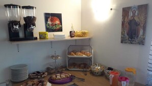 A breakfast buffet with various pastries, a coffee station, and a decorative painting. - Apartment 'Deluxe Room' with Private Terrace, Wi-Fi and Air Conditioning (Valle Clavia)