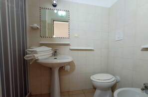 Une salle de bain équipée d’un lavabo, de toilettes et d’un bidet.