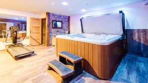 Un moderno cuarto de spa con un jacuzzi, una caminadora y una pared de madera.