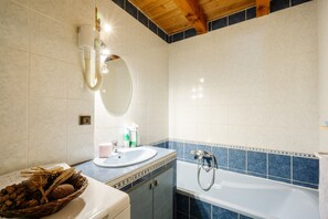 Une salle de bain avec un lavabo, un miroir et une baignoire.